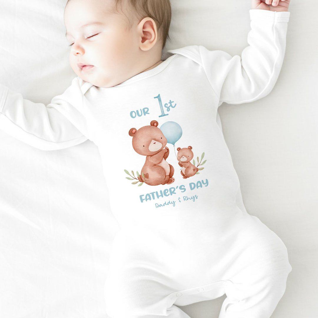 Personalised white Father's Day baby grow/sleepsuit that says 'Our 1st Father's Day Daddy & Rhys'. This design features 2 brown bears and a blue balloon