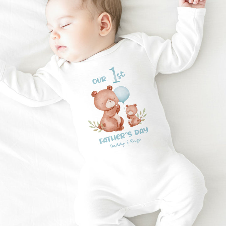 Personalised white Father's Day baby grow/sleepsuit that says 'Our 1st Father's Day Daddy & Rhys'. This design features 2 brown bears and a blue balloon