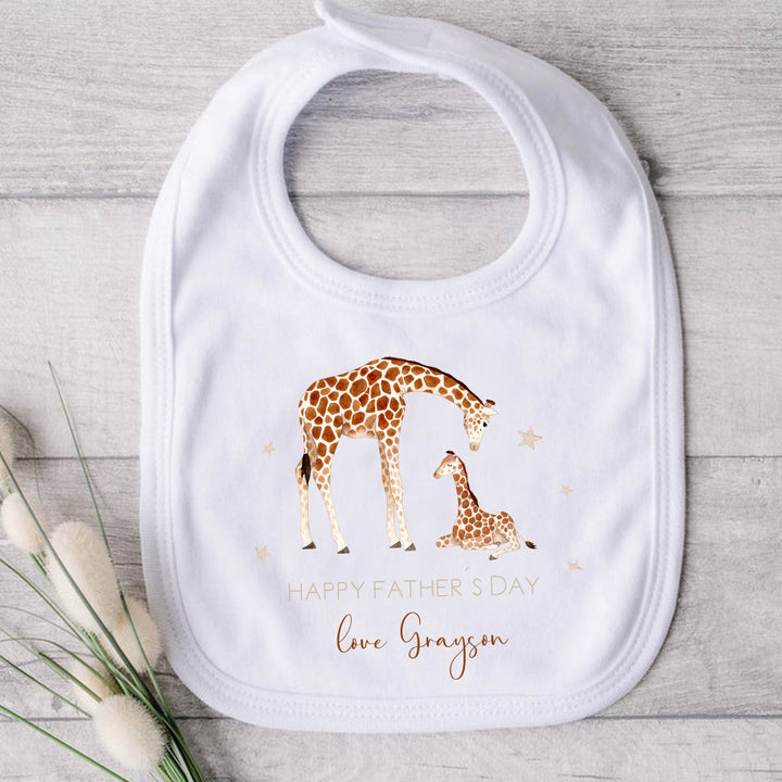 Personalised beige Father's Day baby bib that says 'Happy Father's Day Love Grayson'. This design features 2 giraffes surrounded by stars