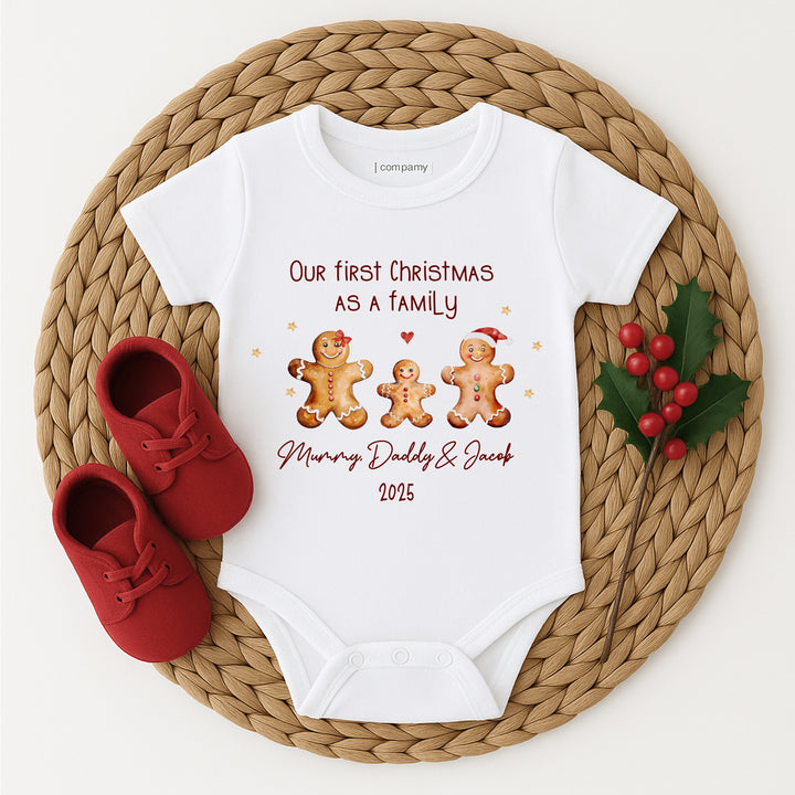 Baby onesie with Christmas design and red shoes on a woven mat