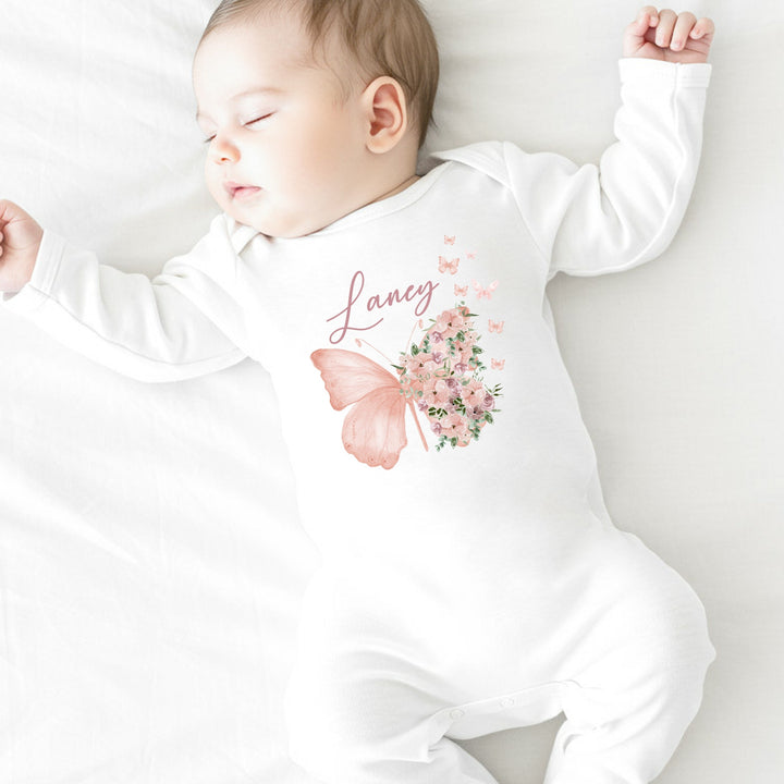 a personalised white baby grow that says 'Laney'. This design features a butterfly with flowers next to it
