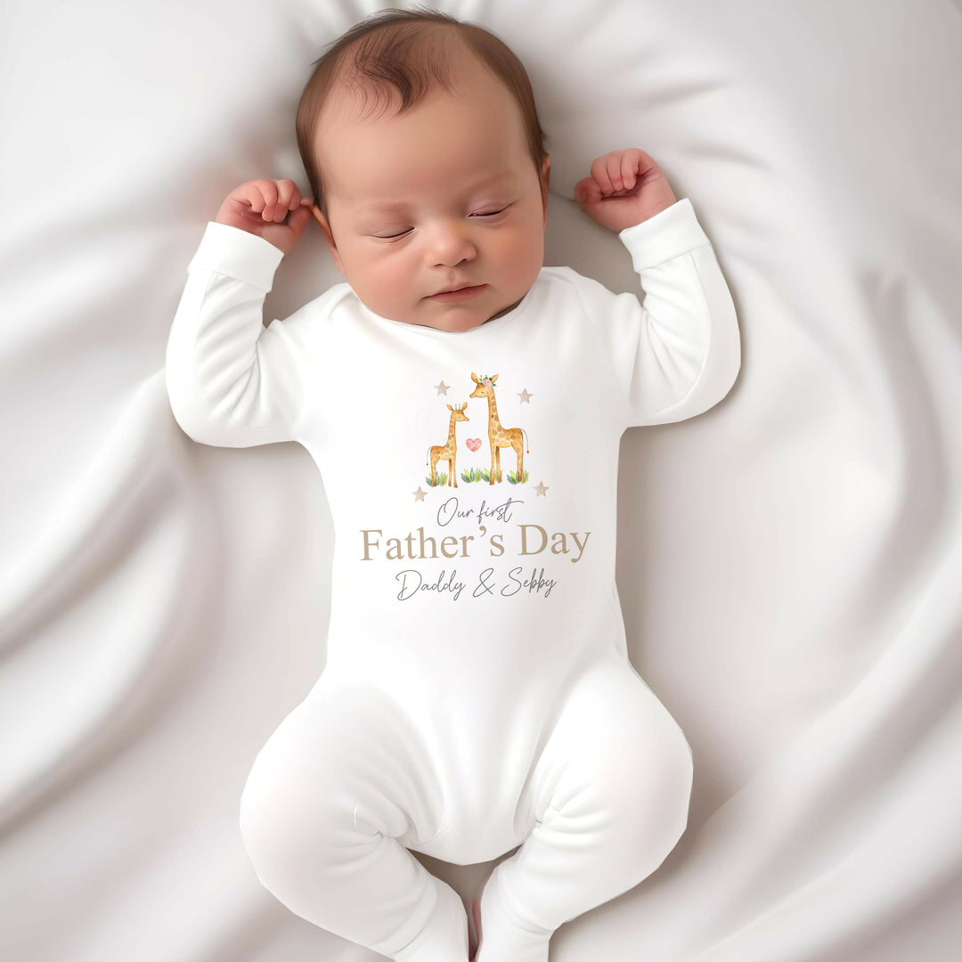 Personalised white Father's Day baby grow/sleepsuit that says 'Our First Father's Day Daddy & Sebby'. This design features 2 giraffes