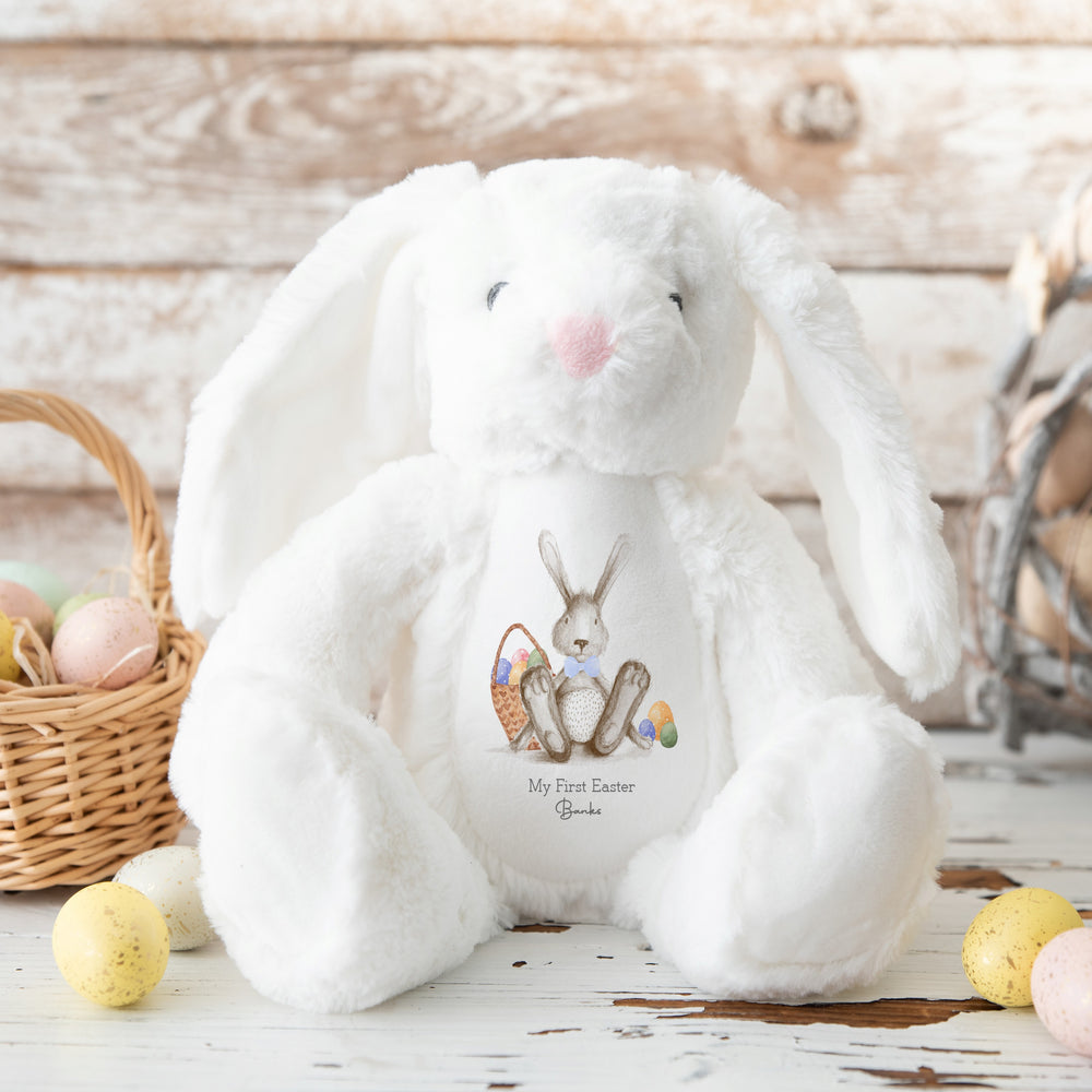 Personalised white bunny Easter teddy saying 'My First Easter Banks'. This design features a grey bunny wearing a blue bow tie and a basket filled with Easter eggs