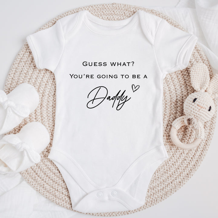 Baby announcement vests that says: 'Guess what? You're going to be a daddy' with heart 