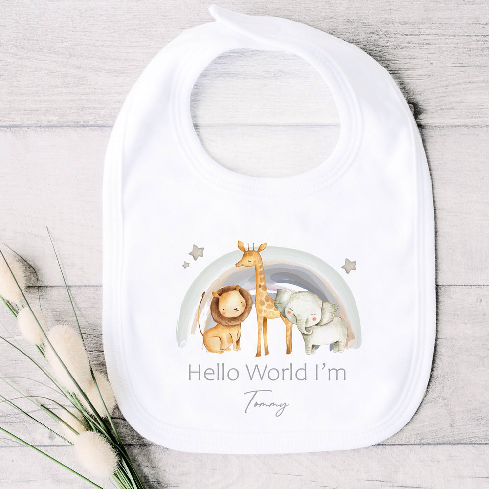 A personalised white baby bib that says 'Hello World I'm Tommy'. This design features a water colour rainbow with a lion, giraffe and a lion standing in front of it 