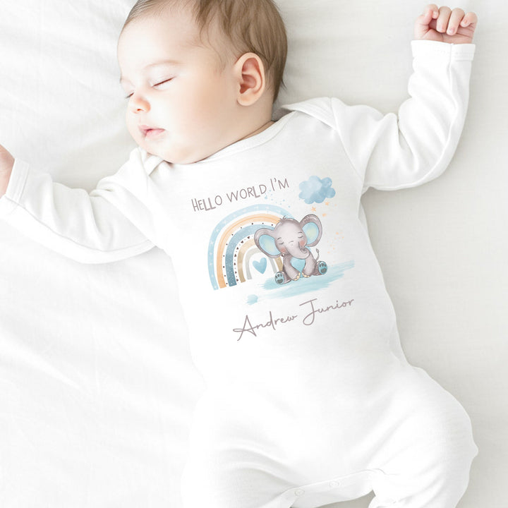 Personalised white baby grow that says 'Hello World I'm Nathan'. This design features a blue rainbow with an elephant in front it 