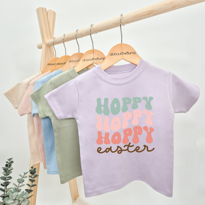 Lilac retro style Easter t-shirt that says 'Hoppy Easter'. This design features the word hoppy 3 times in 3 different colours stacked 