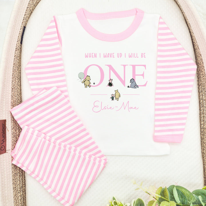 Personalised Pink stripe pyjamas that say 'When I wake up I will be ONE Elsie-Mae'. This design features the Classic Winnie the Pooh, Piglet and Eyore