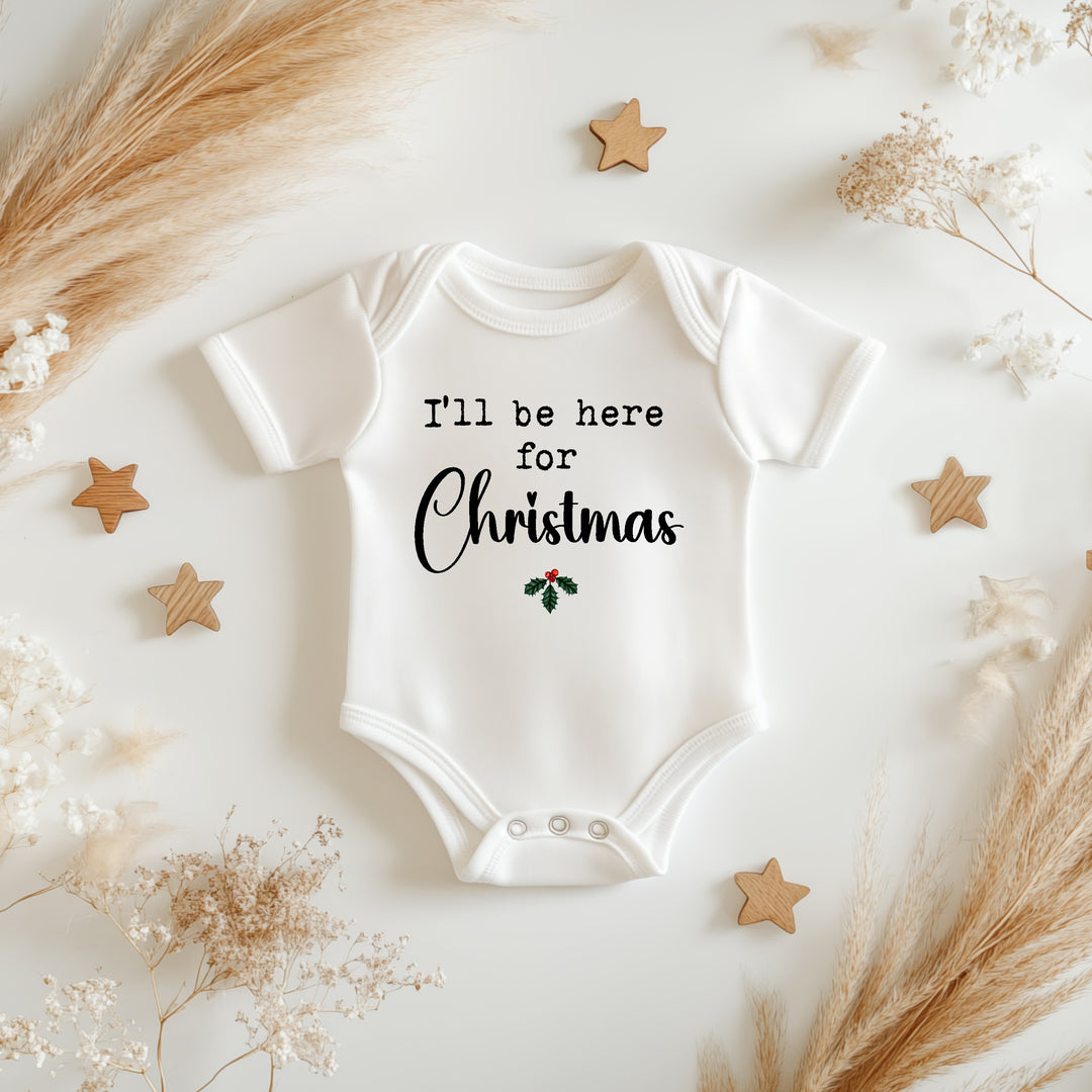 Baby announcement vests that says: I'll be home for Christmas with holly under