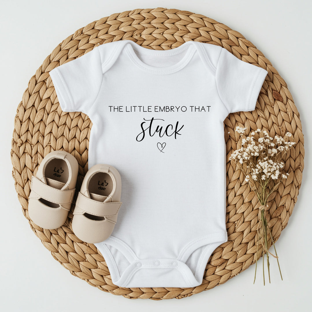 Baby announcement vests that says: 
The little embryo that stuck with a heart underneath