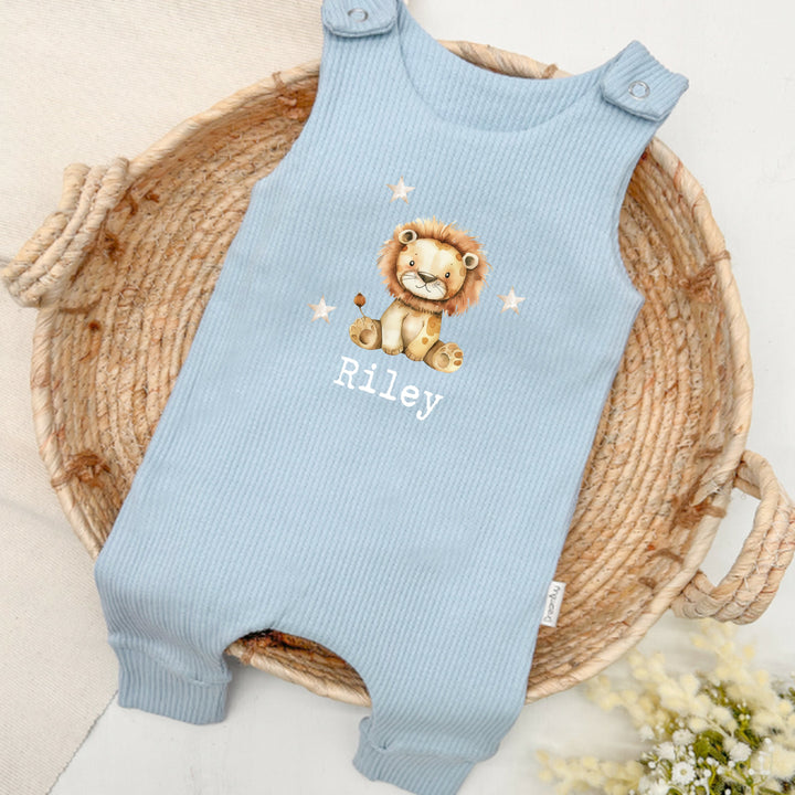 Personalised blue ribbed dungarees that say 'Riley'. This design features a lion surrounded by stars