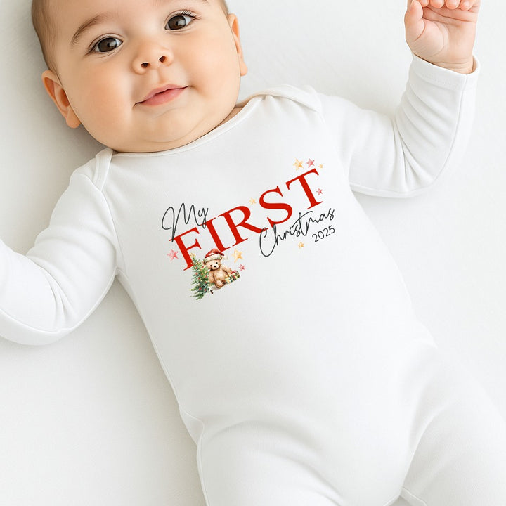 Baby wearing a white onesie with 'My First Christmas 2023' text and graphics.