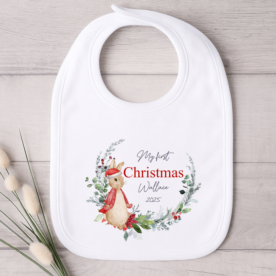 Baby bib with Christmas design and text on a wooden surface