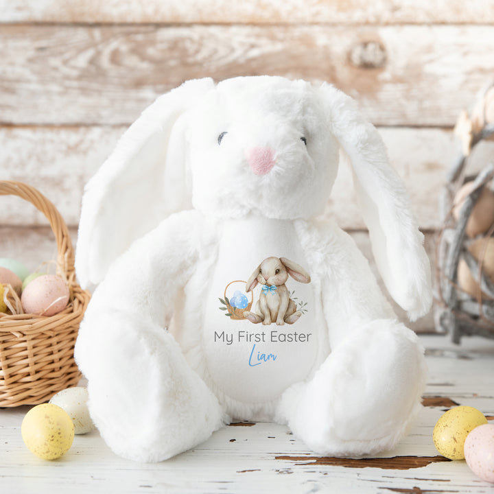 Personalised white bunny Easter teddy that says 'My First Easter Liam'. This design features a brown bunny wearing a bow tie next to an Easter basket full of blue Easter eggs