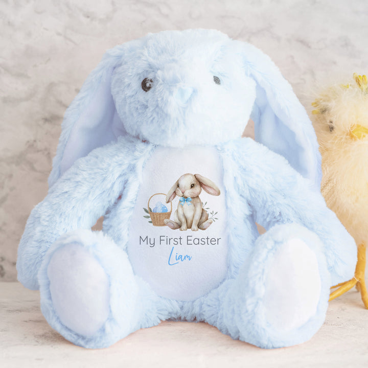 Personalised blue bunny Easter teddy that says 'My First Easter Liam'. This design features a brown bunny wearing a bow tie next to an Easter basket full of blue Easter eggs