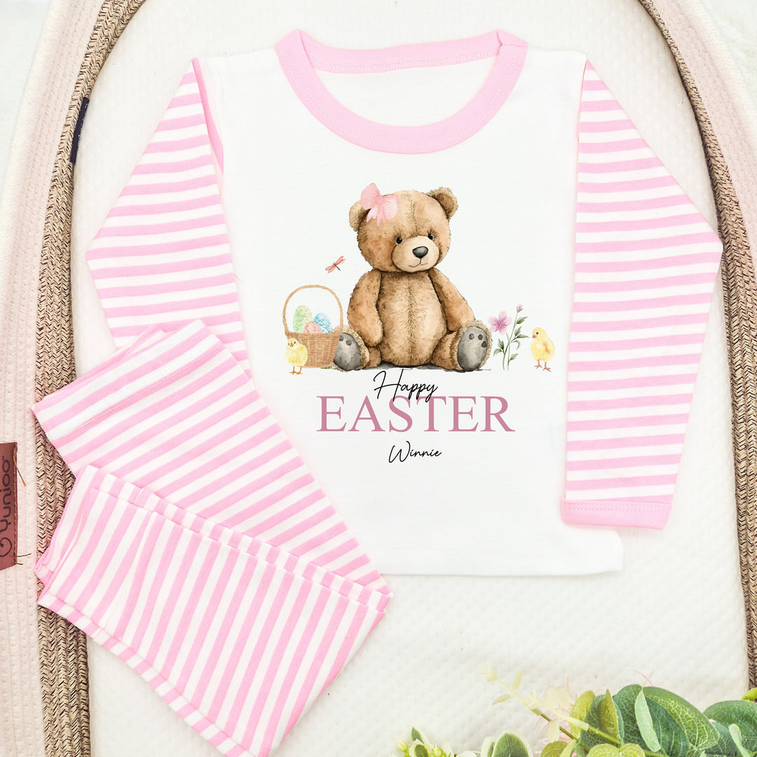 Peronalised pink stripe Easter pyjamas that say 'Happy Easter Winnie'. This design features a teddy wearing a pink bow surrounded by an easter basket