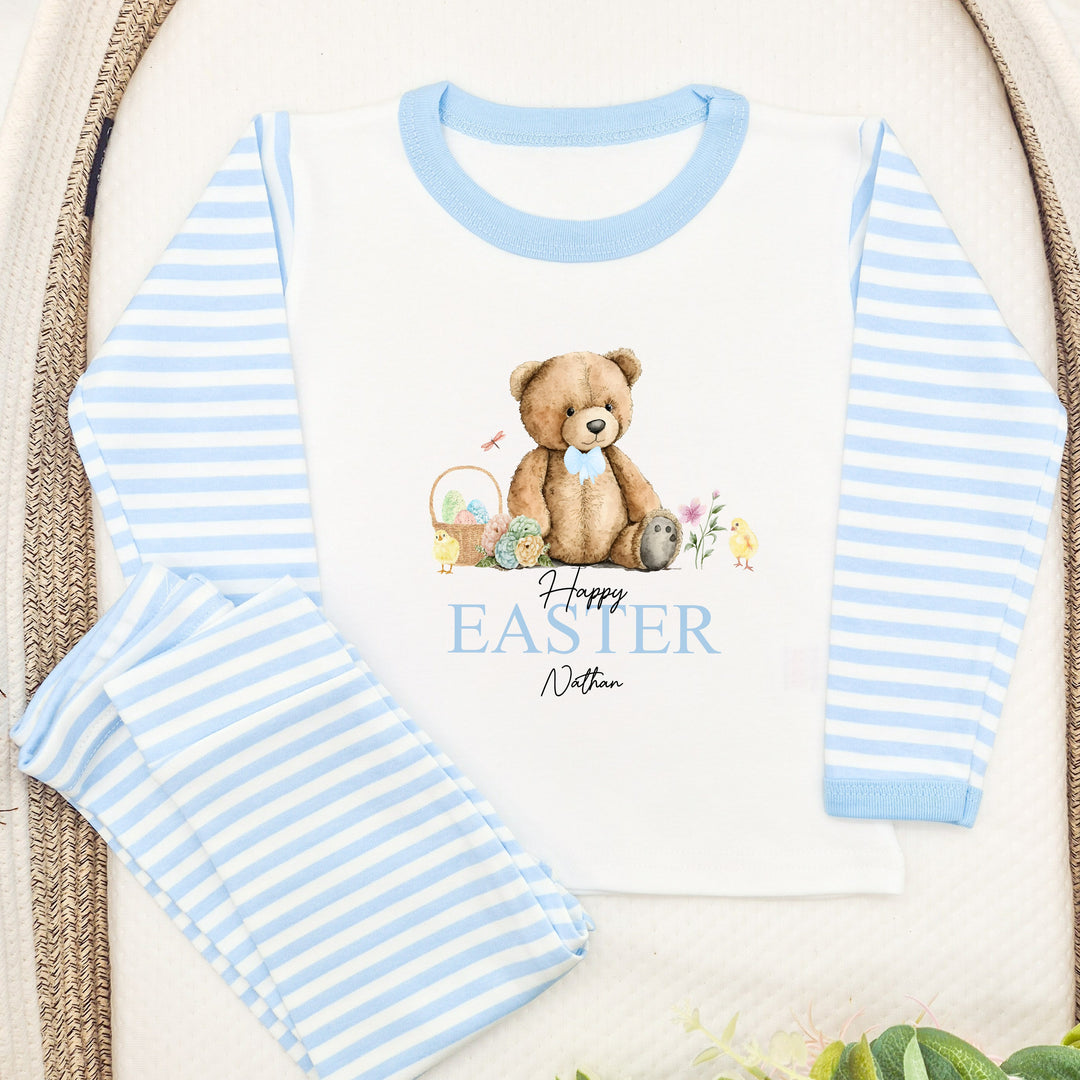 Personalised blue stripe Easter pyjamas saying 'Happy Easter Nathan'. This design features a teddy wearing a blue bow tie sitting next to an easter egg basket