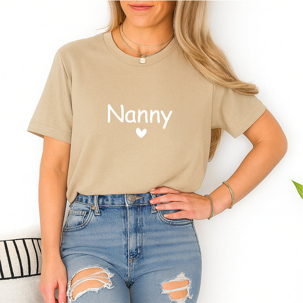 Person wearing a beige t-shirt with 'Nanny' printed on it, standing against a white background.