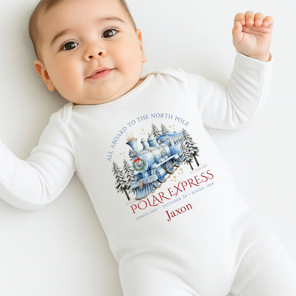 Baby wearing a 'Polar Express' themed onesie on a white background