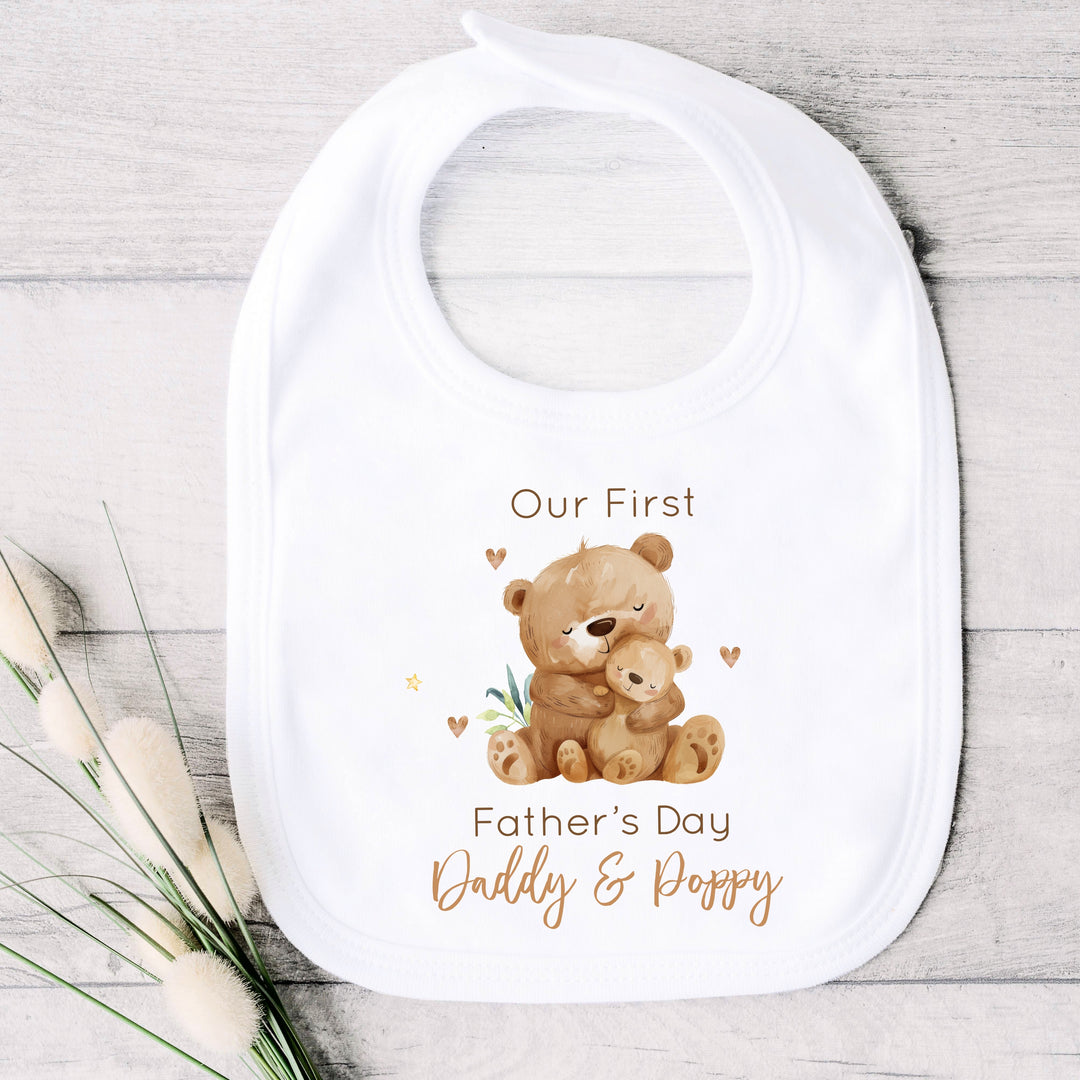 Personalised white Father's Day baby bib that says 'Our First Father's Day Daddy & Poppy'. This design features 2 brown bears