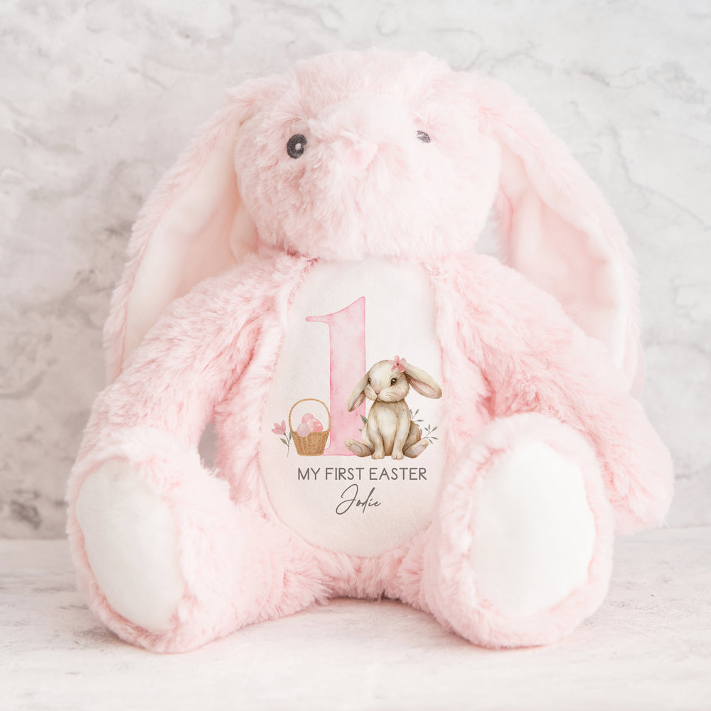 Personalised pink bunny Easter teddy saying 'My First Easter Jodie'. This design features a big pink 1 with a brown bunny with a pink bow one side and an Easter basket full of pink Easter eggs the other side