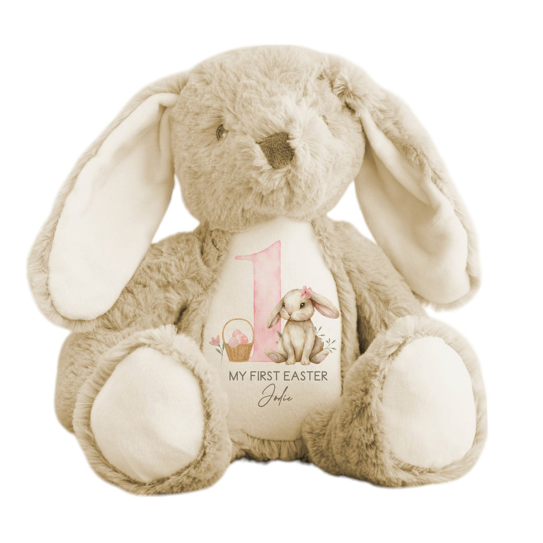 Personalised beige bunny Easter teddy saying 'My First Easter Jodie'. This design features a big pink 1 with a brown bunny with a pink bow one side and an Easter basket full of pink Easter eggs the other side