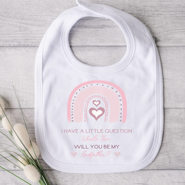 Baby Bib that says: 'I have a little question Uncle Tom Will you be my godfather?' This is in pink text with a pink rainbow above the text