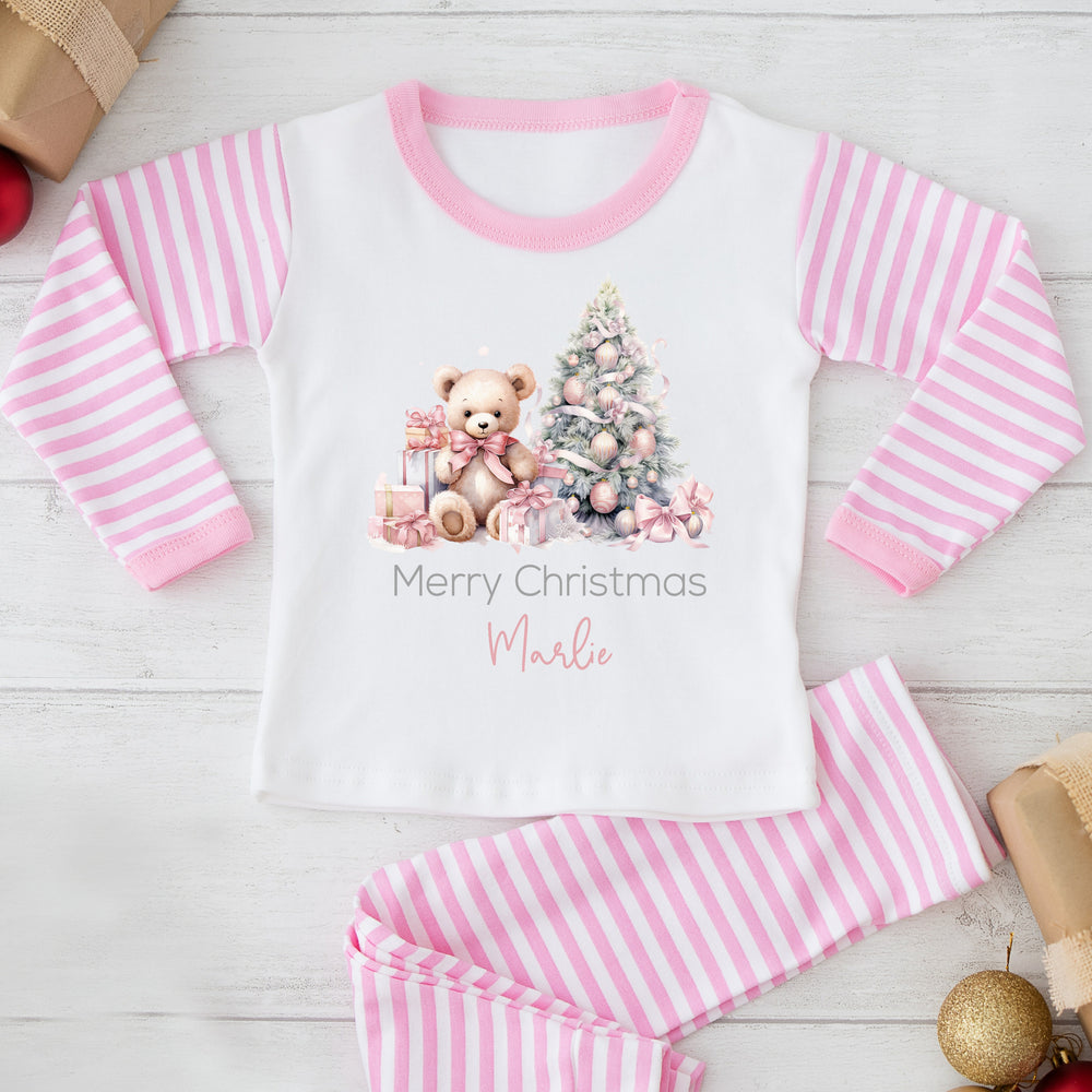 A white teddy bear and a Christmas tree with gifts, text 'Merry Christmas' and the name 'Marlo' on a pink and white striped background.