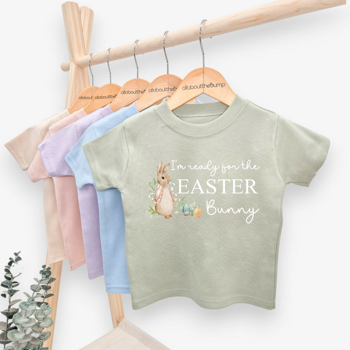 Sage Green childrens t-shirt that says 'I'm ready for the Easter Bunny'. This design features a rabbit wearing a beige jacket standing next to some Easter eggs