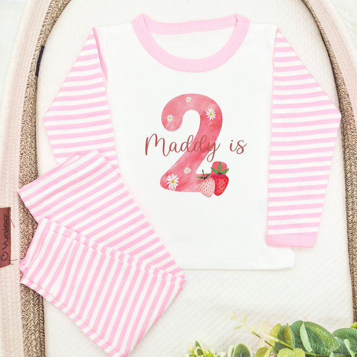 Personalised pink stripe birthday pyjamas saying 'Maddy is 2'. This design features a big pink 2 with strawberry and daisies surronding it