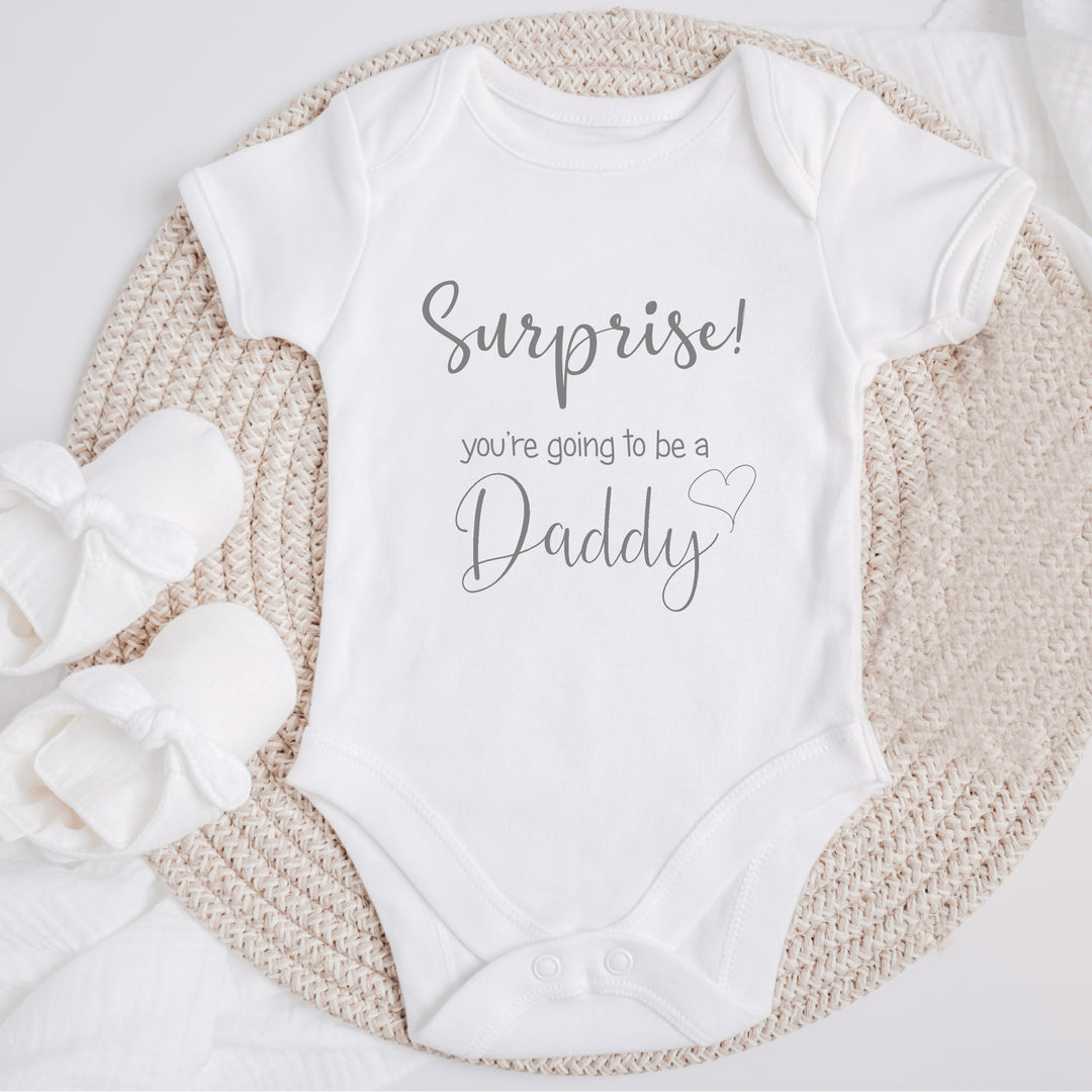 Baby announcement vests that says: Suprise you're going to be a Daddy 