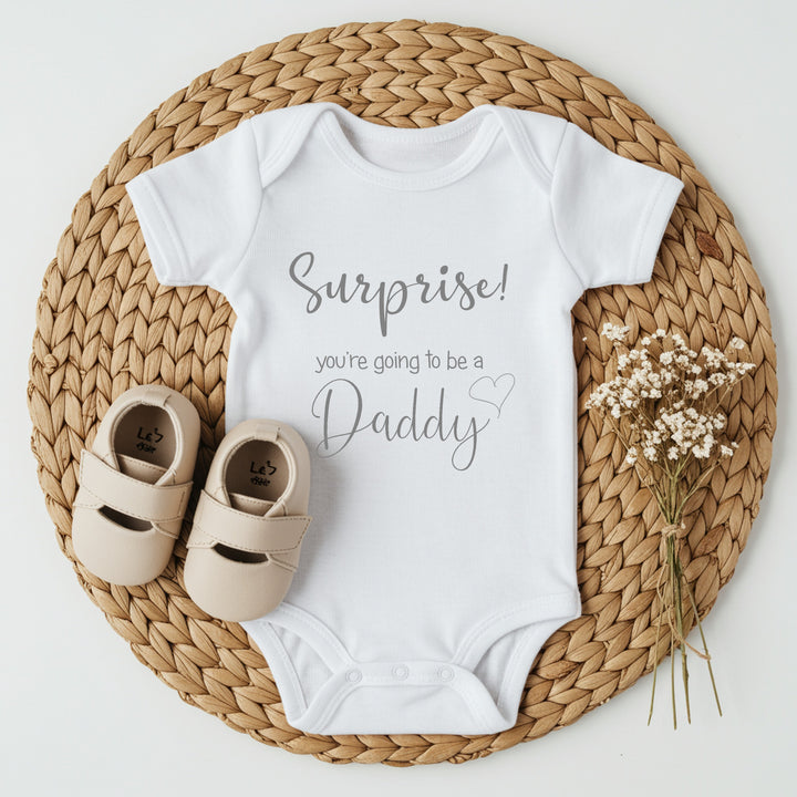 Baby announcement vests that says: Suprise you're going to be a Daddy 