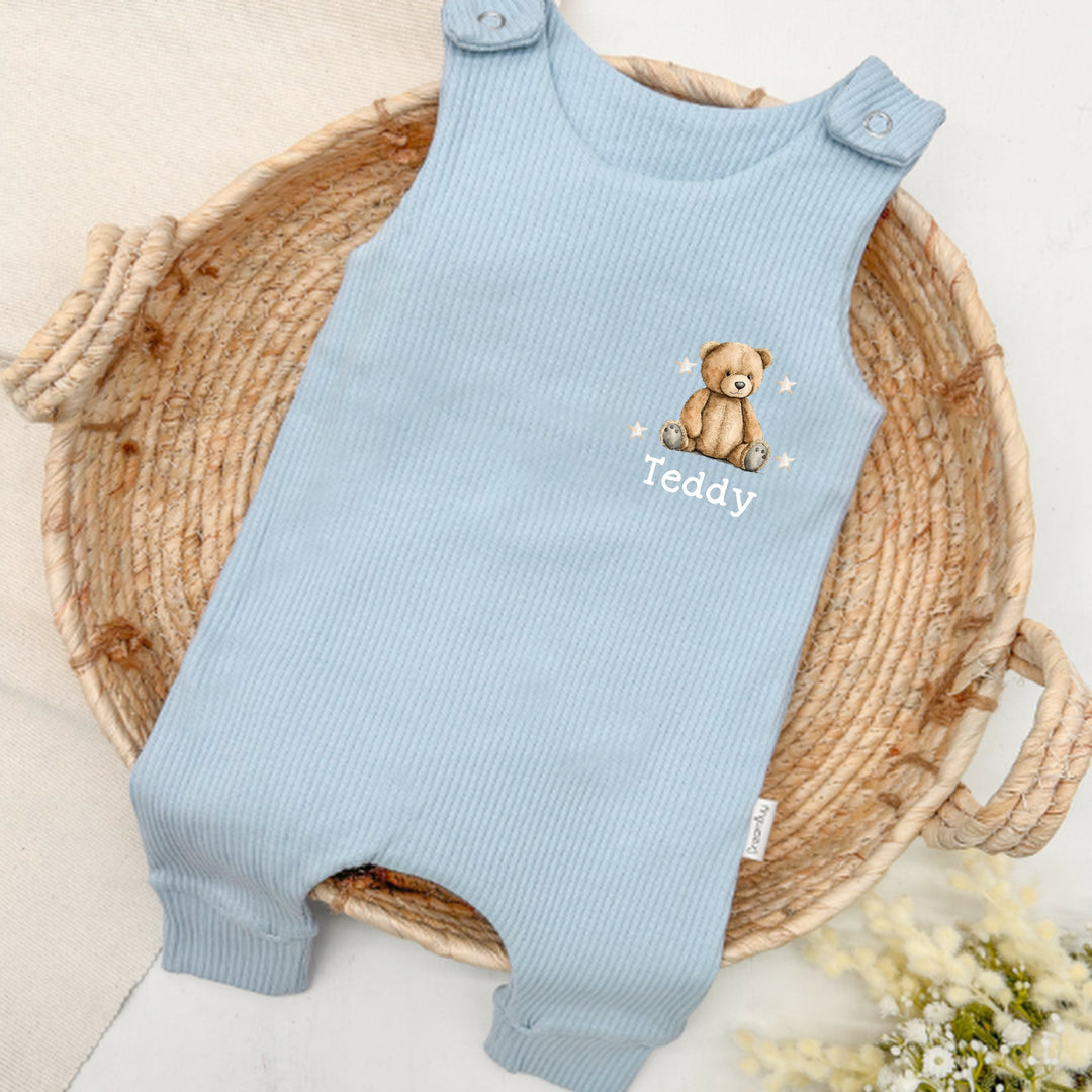 Personalised blue ribbed dungarees that say 'Teddy'. This design features a teddy bear surrounded by stars