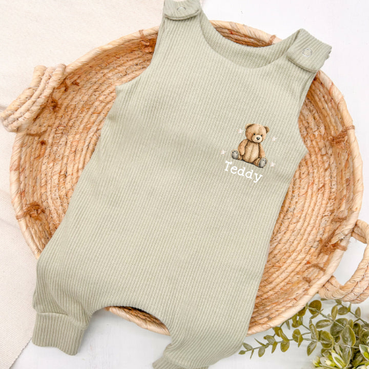 Personalised sage green ribbed dungarees that say 'Teddy'. This design features a teddy bear surrounded by stars