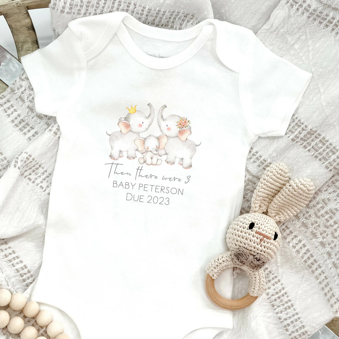 Baby announcement vests that says: 'Then there were 3 Baby Peterson due January 2023' With 3 elephants above the text