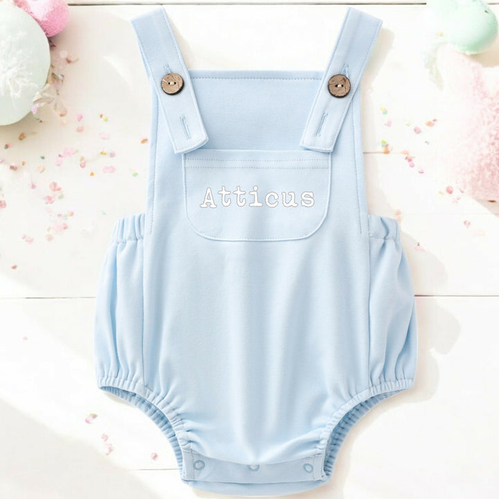 a personalised blue dungarees that say 'Atticus'