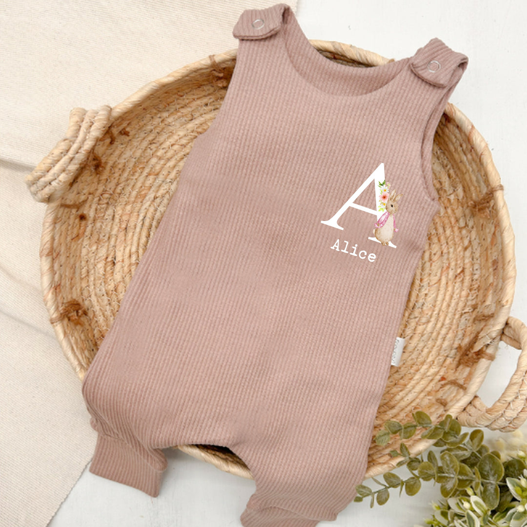 Personalised brown ribbed dungarees that say 'Alice'. This design features a rabbit wearing a pink jacket