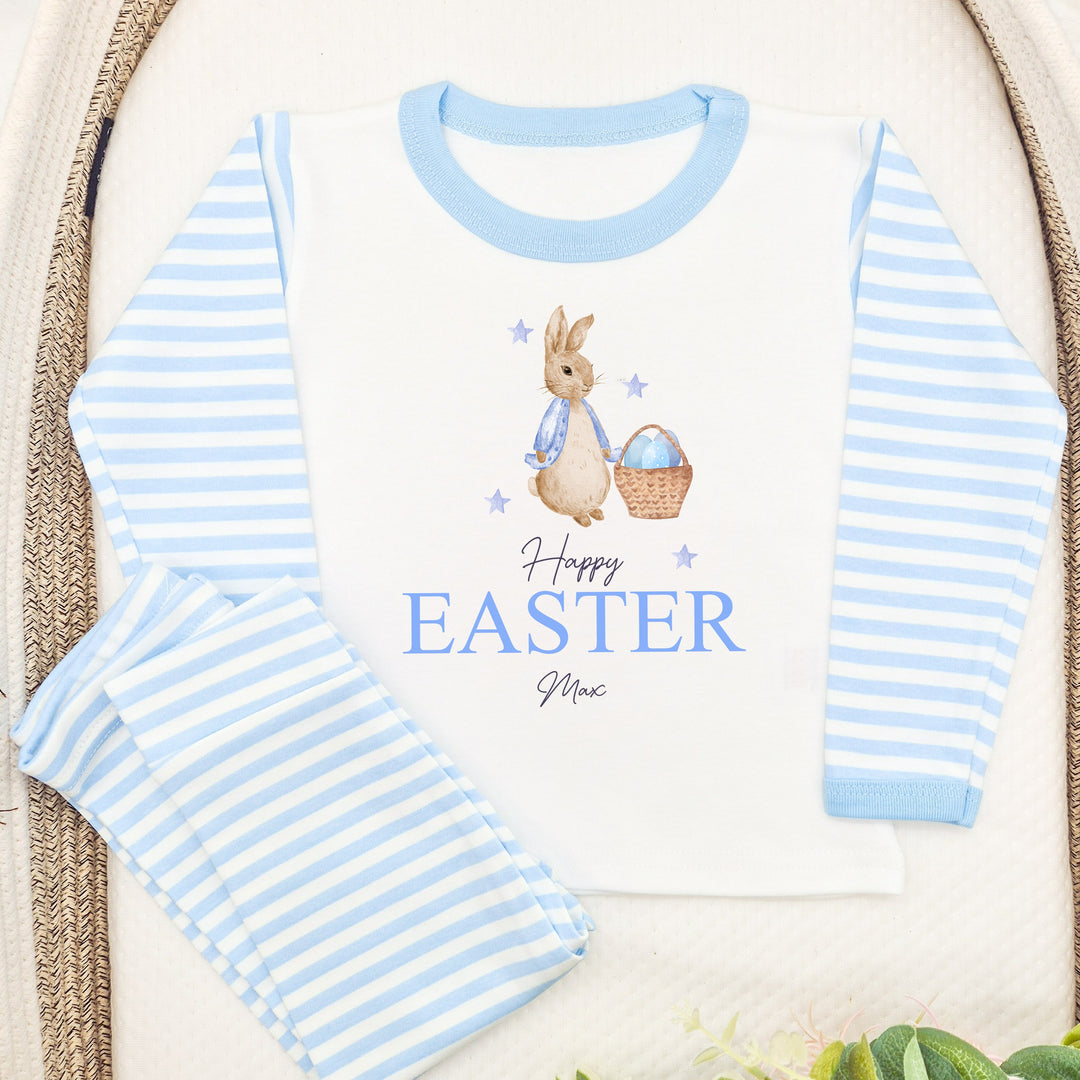 Personalised blue stripe Easter pyjamas that say 'Happy Easter Max'. This design features a rabbit wearing a blue jacket next to a basket with Blue Easter eggs