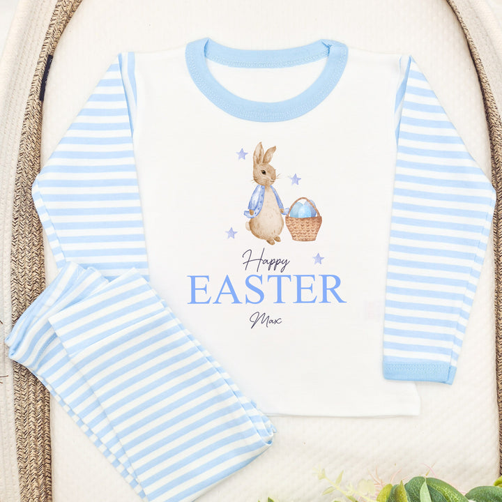 Personalised blue stripe Easter pyjamas that say 'Happy Easter Max'. This design features a rabbit wearing a blue jacket next to a basket with Blue Easter eggs