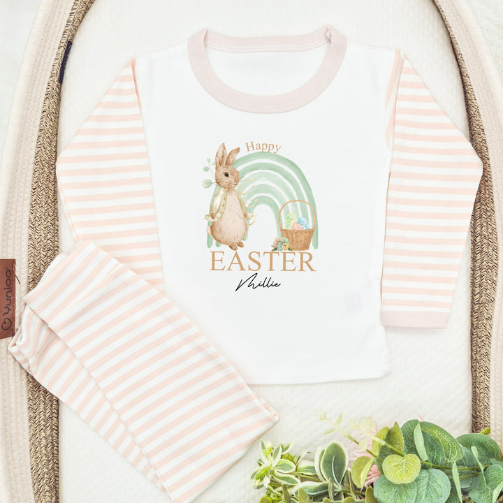 Personalised Beige stripe Easter pyjamas saying 'Happy Easter Millie'. This design features a sage green rainbow and a rabbit wearing a beige jacket