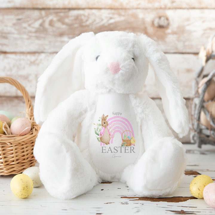 Personalised white bunny Easter teddy that says 'Happy Easter Gracie'. This design features a pink rainbow with a rabbit wearing a pink jacket on one side and an Easter basket on the other side