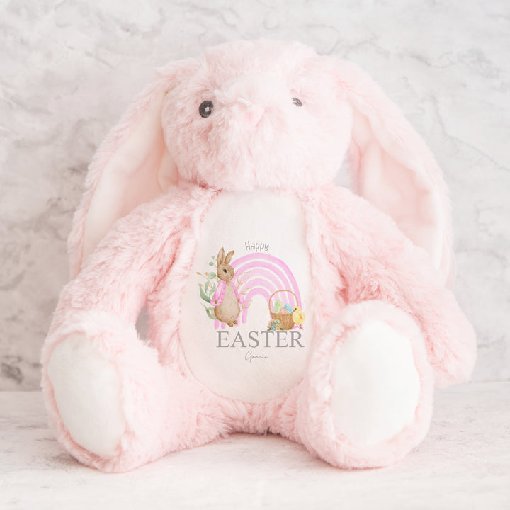 Personalised pink bunny Easter teddy that says 'Happy Easter Gracie'. This design features a pink rainbow with a rabbit wearing a pink jacket on one side and an Easter basket on the other side