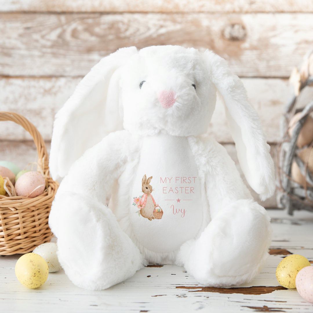 Personalised white bunny Easter teddy that says 'My First Easter Ivy'. This design features a rabbit wearing a pink jacket holding an Easter basket