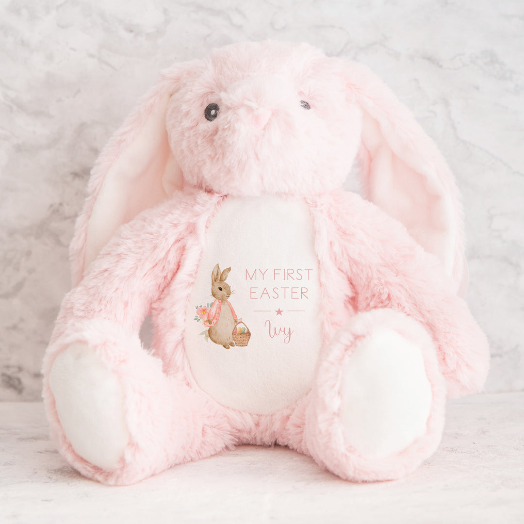 Personalised pink bunny Easter teddy that says 'My First Easter Ivy'. This design features a rabbit wearing a pink jacket holding an Easter basket