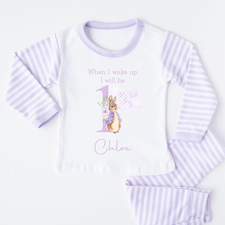 A pair of lilac and white stripe children's birthday pyjamas with a purple bunny rabbit with balloons design saying "When I wake up I will be one" with the name "Chloe".