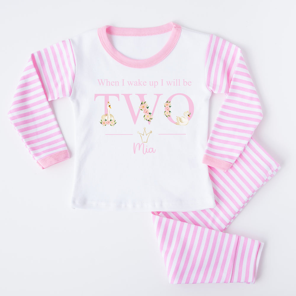 Personalised Pink stripe pyjamas that say 'When I wake up I will be TWO Mia'. This design features white swans and pink flowers