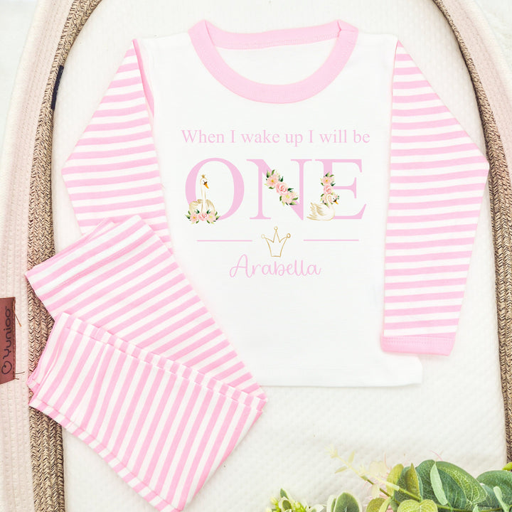 Personalised Pink stripe pyjamas that say 'When I wake up I will be ONE Arabella'. This design features white swans and pink flowers