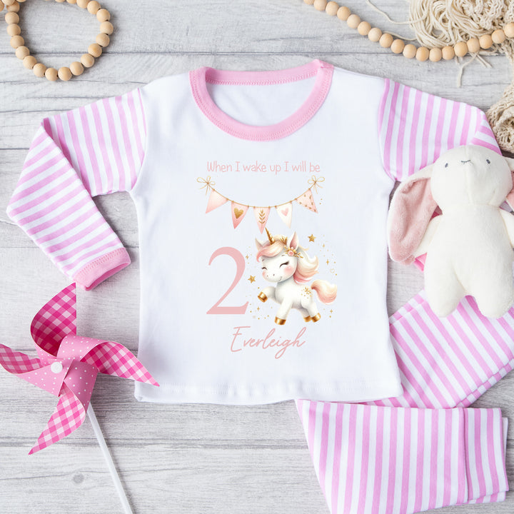 Personalised pink stripe birthday pyjamas that say 'When I wake up I will be 2 Everleigh'. This design features a pink pastel unicorn and pink bunting 