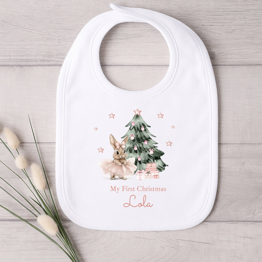 Baby bib with Christmas tree and baby reindeer design on a wooden surface
