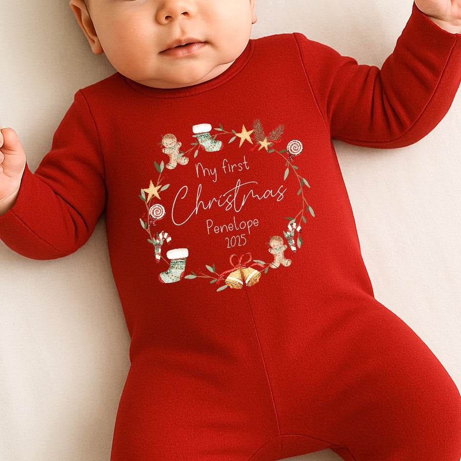 Baby in a red Christmas-themed onesie with decorative elements and text.